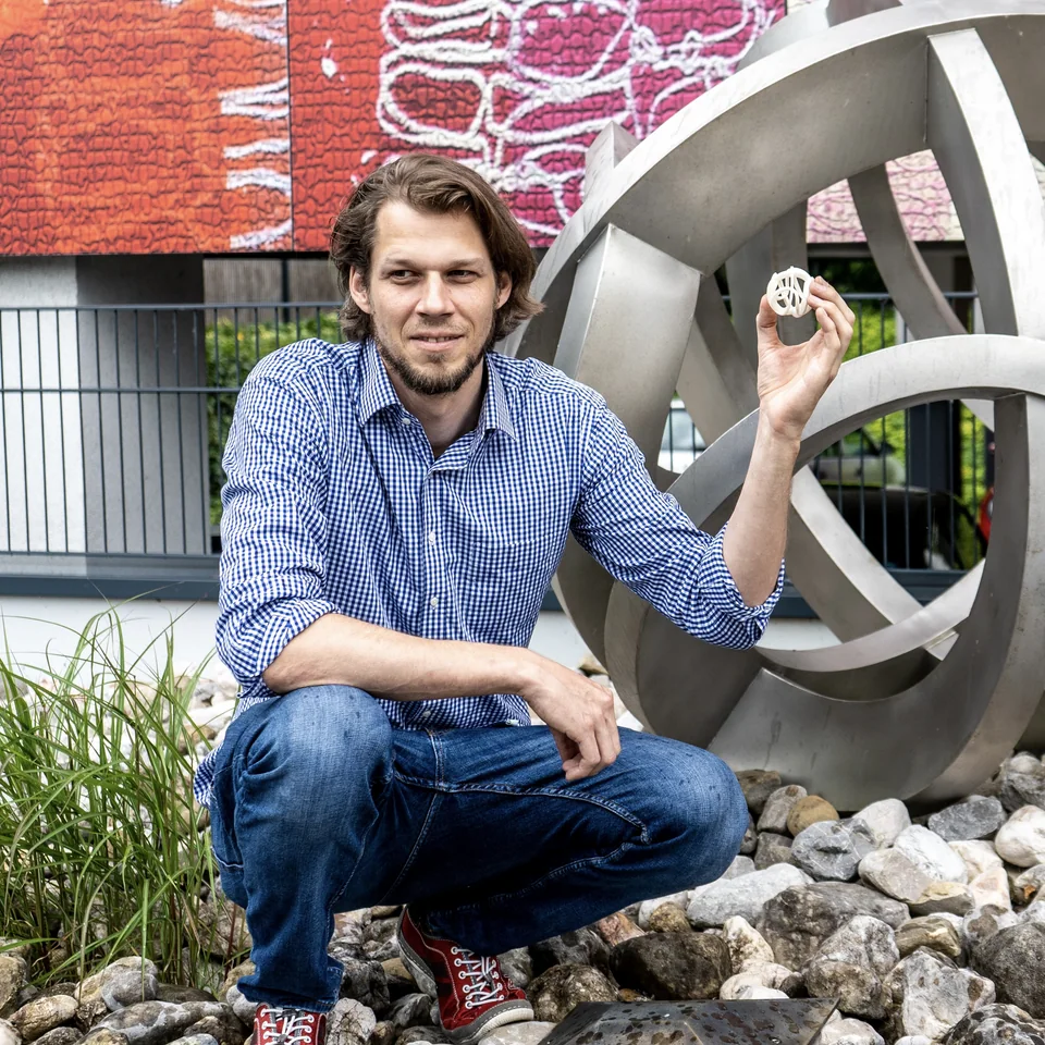 Alexander Schreilechner mit einer Medaille vor einer seiner Metallskulpturen